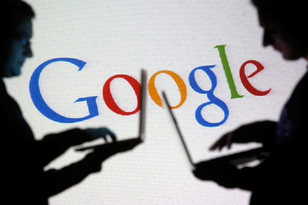 People are silhouetted as they pose with laptops in front of a screen projected with a Google logo, in this picture illustration taken in Zenica. (REUTERS file photo)