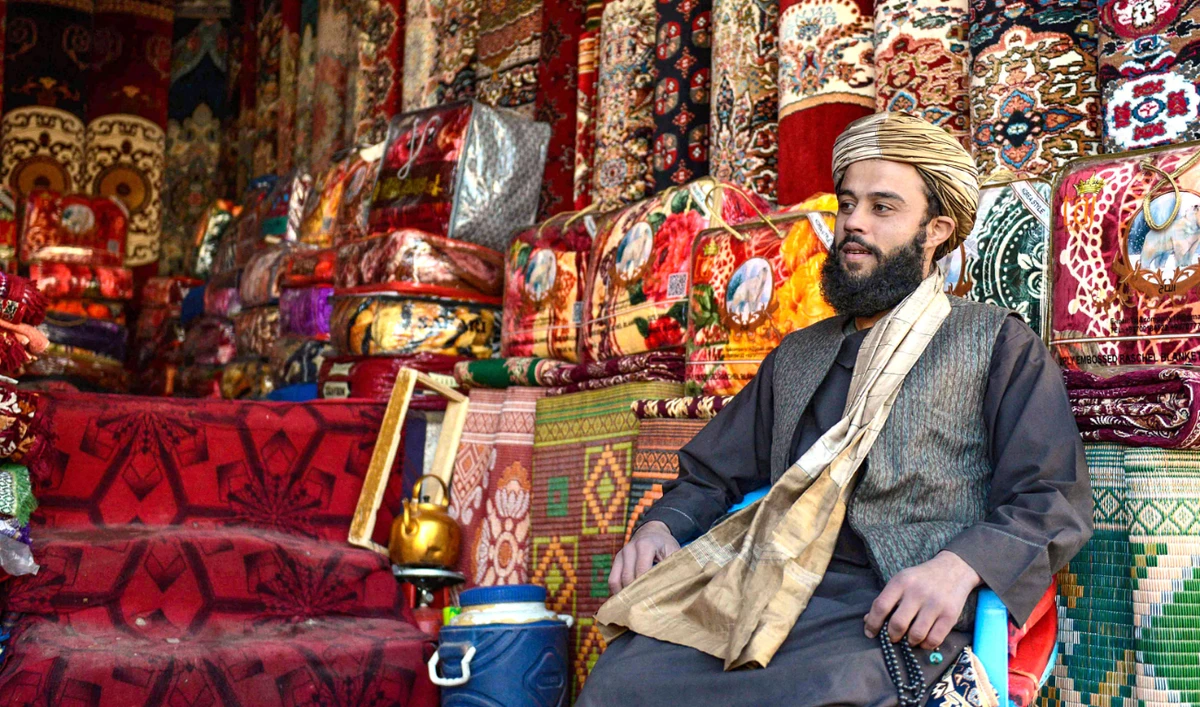 An Afghan shopkeeper selling carpets and woven items wait for customers in his shop in Kandahar on Thursday. Millions of Afghans have had no steady income for months. (AFP)