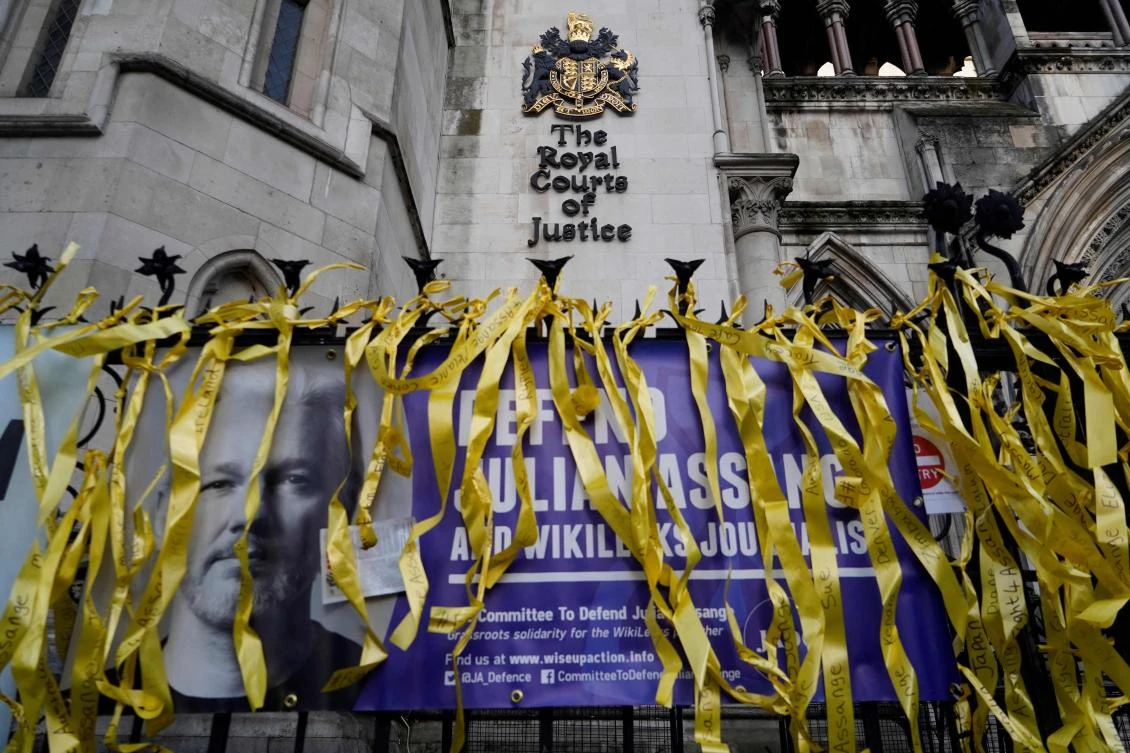 A banner supporting WikiLeaks founder Julian Assange, is displayed outside the Royal Courts of Justice in London on December 10, 2021. (AFP)