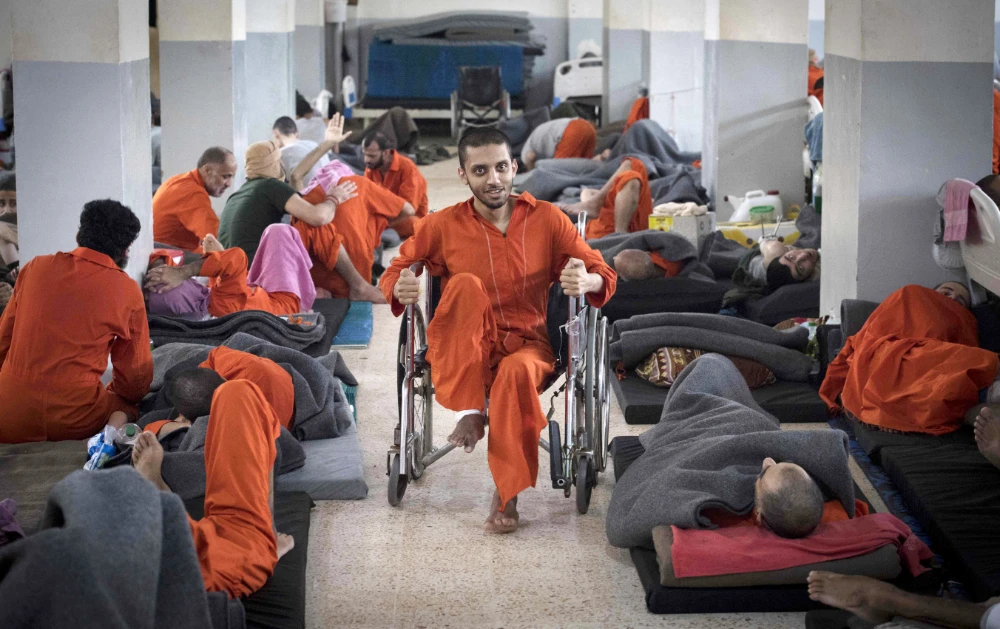 Men, allegedly affiliated with the Daesh group, gather in a prison cell in the northeastern Syrian city of Hasakeh on October 26, 2019. (AFP)