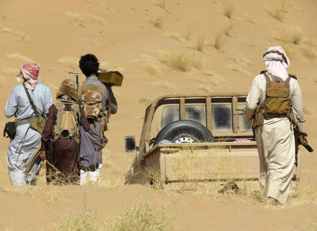 Yemeni pro-government fighters carry their equipment to a position during fighting with Huthi rebels on the al-Jawba frontline south of Marib, the last remaining government stronghold in northern Yemen, on December 7, 2021. (AFP)