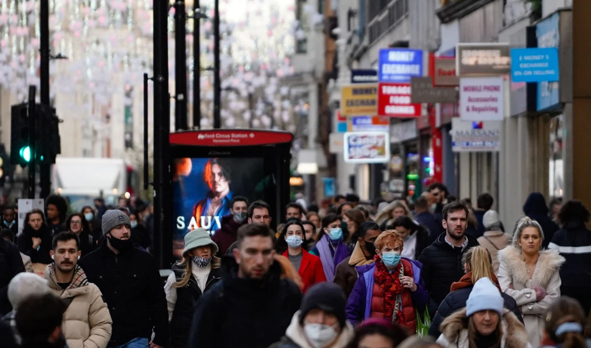 Shoppers, some wearing face coverings to combat the spread of the coronavirus walk along Oxford Street in central London on December 10, 2021. (AFP)