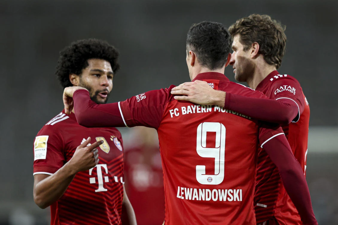 Bayern Munich’s Robert Lewandowski celebrates with Thomas Moeller and Serge Gnabry after scoring his side’s third goal during their Bundesliga match against VfB Stuttgart at Mercedes-Benz Arena in Stuttgart on Tuesday. (AP)
