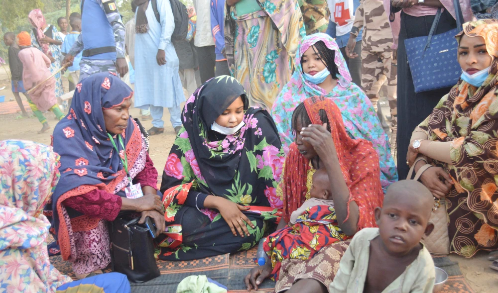 Dahabaya Oumar Souni (C), the wife of Mahamat Idriss Deby Itno speaks with a woman on December 10, 2021 at the site in N'Djamena where 30.000 refugees from Cameroon gather who fled the violence. (AFP)