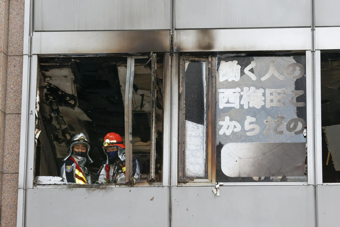 Firefighters stand on a floor at a building where a fire broke out in Osaka, western Japan Friday, Dec. 17, 2021. (AP)