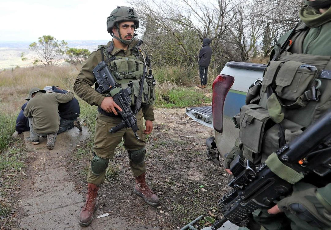 Israeli soldiers stand guard as settlers mourn during the funeral of Yehuda Dimentman in the settlement of Shavei Shomron on Dec. 17, 2021. (AFP)