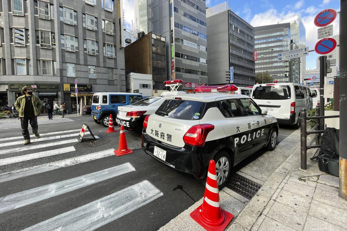 Police cars are pulled up near a building where a fire broke out Friday in Osaka, western Japan, Saturday, Dec. 18, 2021. (AP)