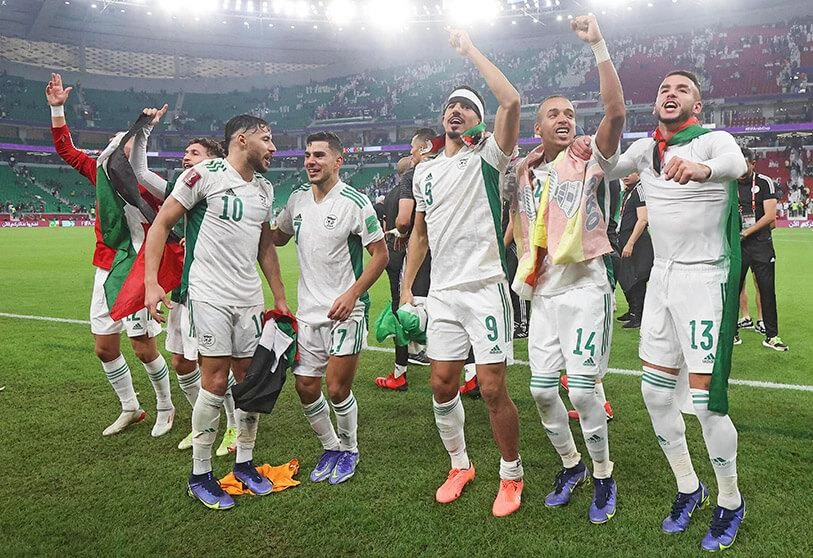 Algeria's players celebrate their victory in the 2021 FIFA Arab Cup semi-final football match between Qatar and Algeria at the Al-Thumama stadium in the Qatari capital Doha on 15 December 2021. (AFP)