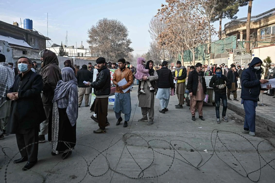 People wait to enter the passport office at a checkpoint in Kabul on December 19, 2021, after Afghanistan's Taliban authorities said they will resume issuing passports. (AFP)