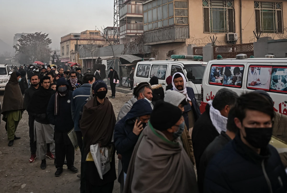 People queue to enter the passport office at a checkpoint in Kabul on December 19, 2021, after Afghanistan's Taliban authorities said they will resume issuing passports. (AFP)