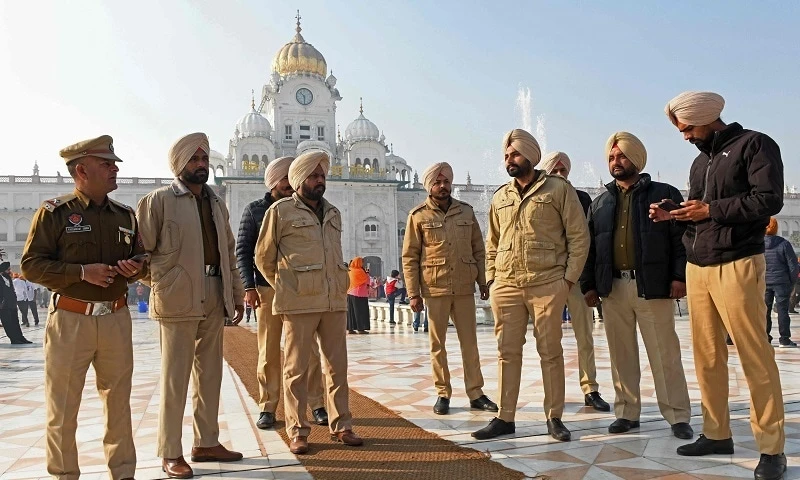 Policemen stand guard outside the Golden Temple in Amritsar on December 19, 2021, a day after a man was beaten to death for allegedly trying to commit an act of sacrilege at the holiest shrine of the Sikh faith. (AFP)