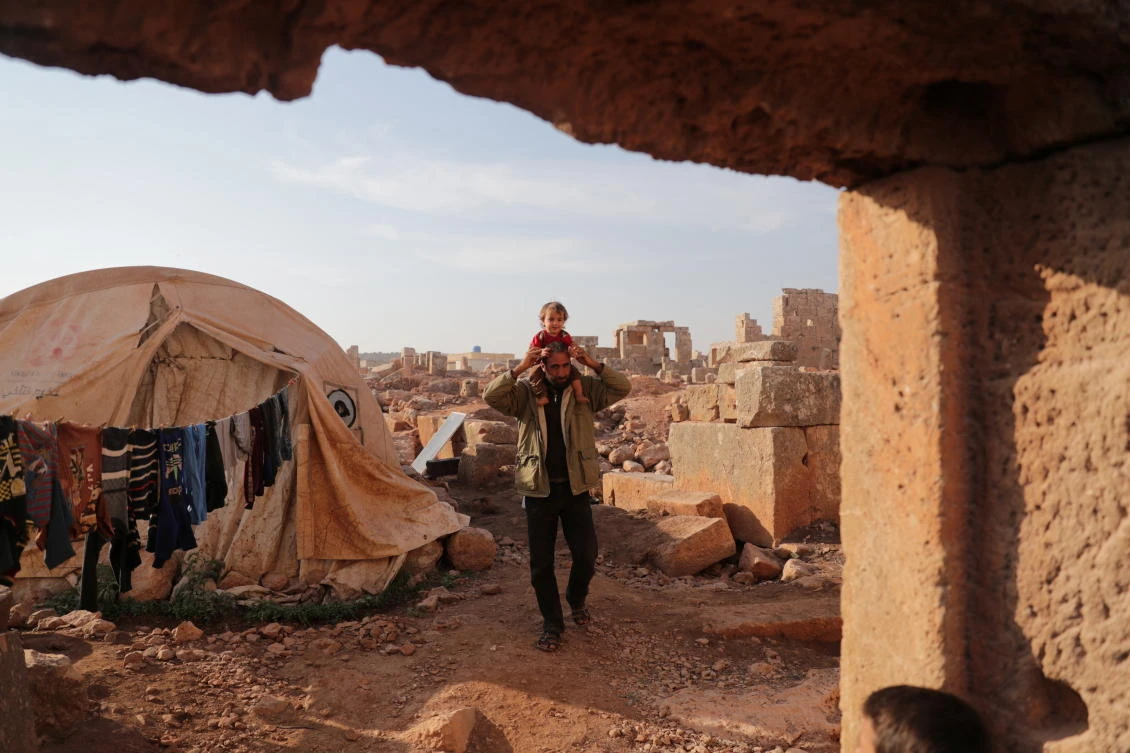 Mohamad Othman, 30, carries his child on his head at the archaeological site of Sarjableh, in the northern countryside of Idlib, Syria on Friday. (Reuters)