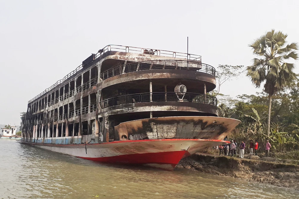 The burnt-out ferry is seen anchored along a coast a day after it caught fire killing at least 39 people in Jhalkathi, 250 km south of Dhaka on December 24, 2021. (AFP)