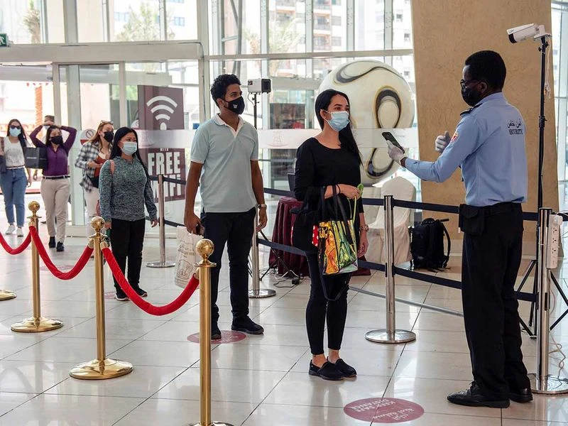 This undated photo shows a safety steward scanning people with a smartphone enabled with Covid-19 detection software, developed by EDE Research Institute, at the entrance of a mall in Abu Dhabi, United Arab Emirates. (Photo courtesy: Online)