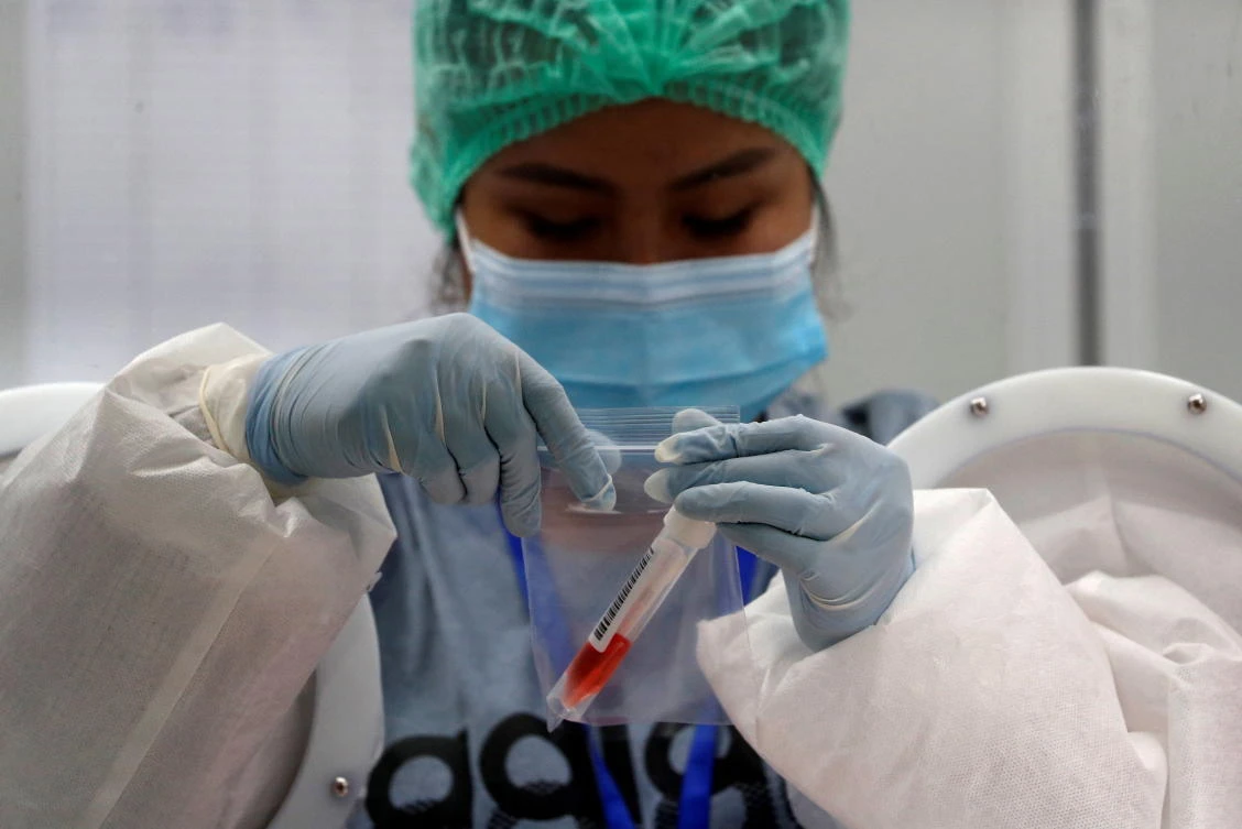 A nurse closes a bag that contains a sample collected from a passenger as it’s mandatory to check all arriving passengers to prevent the spread of the coronavirus, at the international airport in Phuket, Thailand. (Reuters)