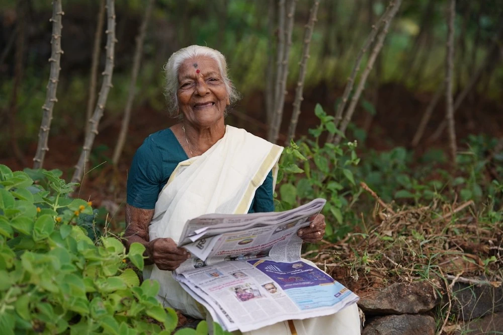Kuttiyamma Konthy who learned to read and write at the age of 104, poses for a photo with a newspaper in Thiruvanchoor village in India’s Kerala state on Dec. 28, 2021. (AN photo by Tibbin Augustine)