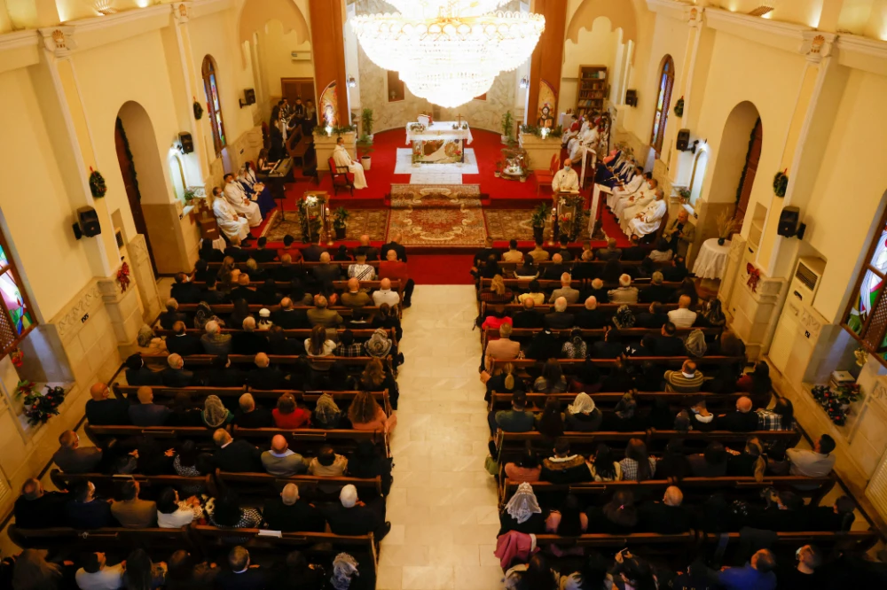 Iraqi Christians pray during a mass on Christmas Eve at St George Chaldean Church in Baghdad, Iraq December 24, 2021. (REUTERS)