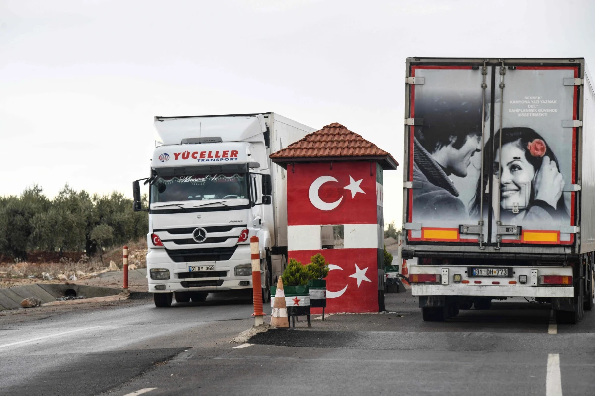 Turkish lorries drive through a checkpoint manned by the Turkish-backed Free Syrian Army in Afrin, northern Syria, on Dec. 8, 2021. (Photo by Rami Al Sayed / AFP)