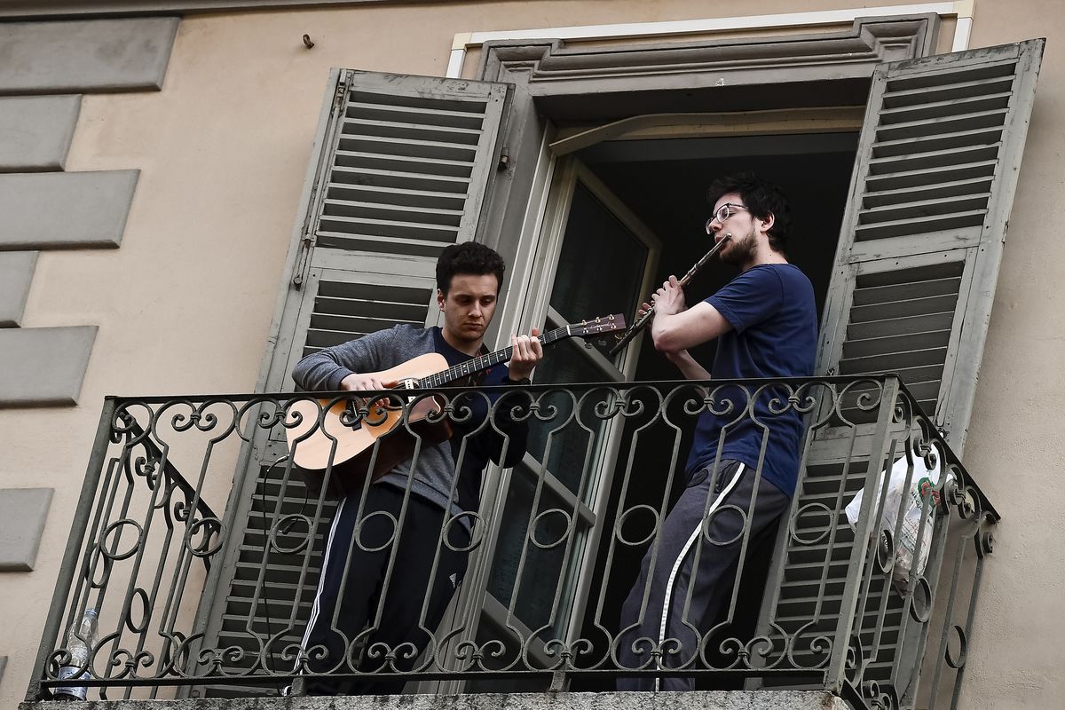 Two men entertain their neighbors from a balcony, during COVID-19 lockdown, in the San Salvario neighborhood of Turin, Italy, Mar. 13, 2020. (Getty Images)