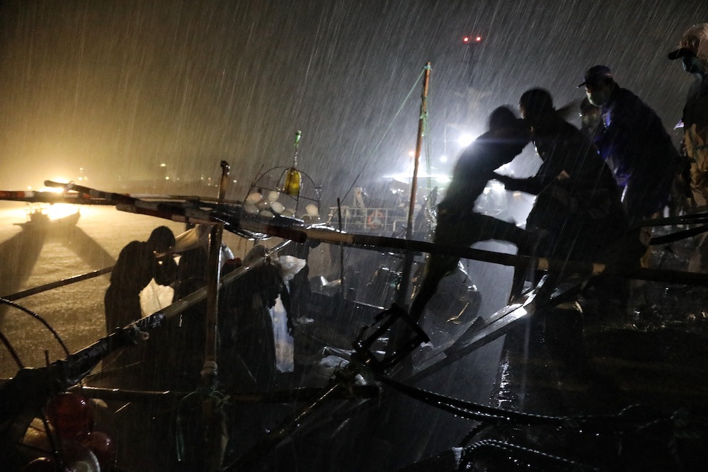 Indonesian officials evacuate Rohingya refugees at the Krueng Geukueh port in Lhokseumawe, Aceh province on December 31, 2021, after they were rescued by Indonesia's navy in the waters off Bireuen. (AFP)