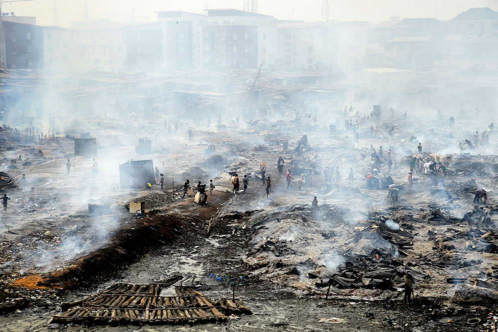 Workers and local residents attempt to salvage goods from the fire in the biggest Lagos wood market, Oko-Baba Sawmill, in Ebute-Metta, district of Lagos, on January 5, 2022. (AFP)