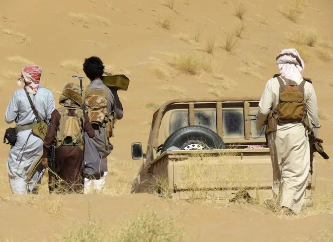 Yemeni pro-government fighters carry their equipment to a position during fighting with Houthis on the Al-Jubah frontline south of Marib. (File/AFP)