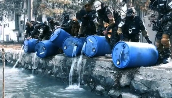 Video footage released by the General Directorate of Intelligence (GDI) shows its agents pouring alcohol stored in barrels into the canal after seizing it during a raid in Kabul, Afghanistan on January 2, 2022. (GDI)