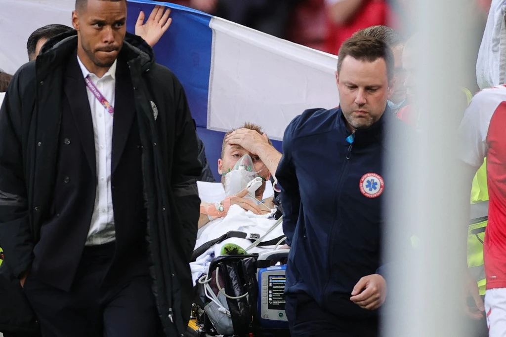 Denmark’s midfielder Christian Eriksen, center, is evacuated after collapsing on the pitch during the UEFA EURO 2020 Group B football match between Denmark and Finland on June 12, 2021. (AFP)