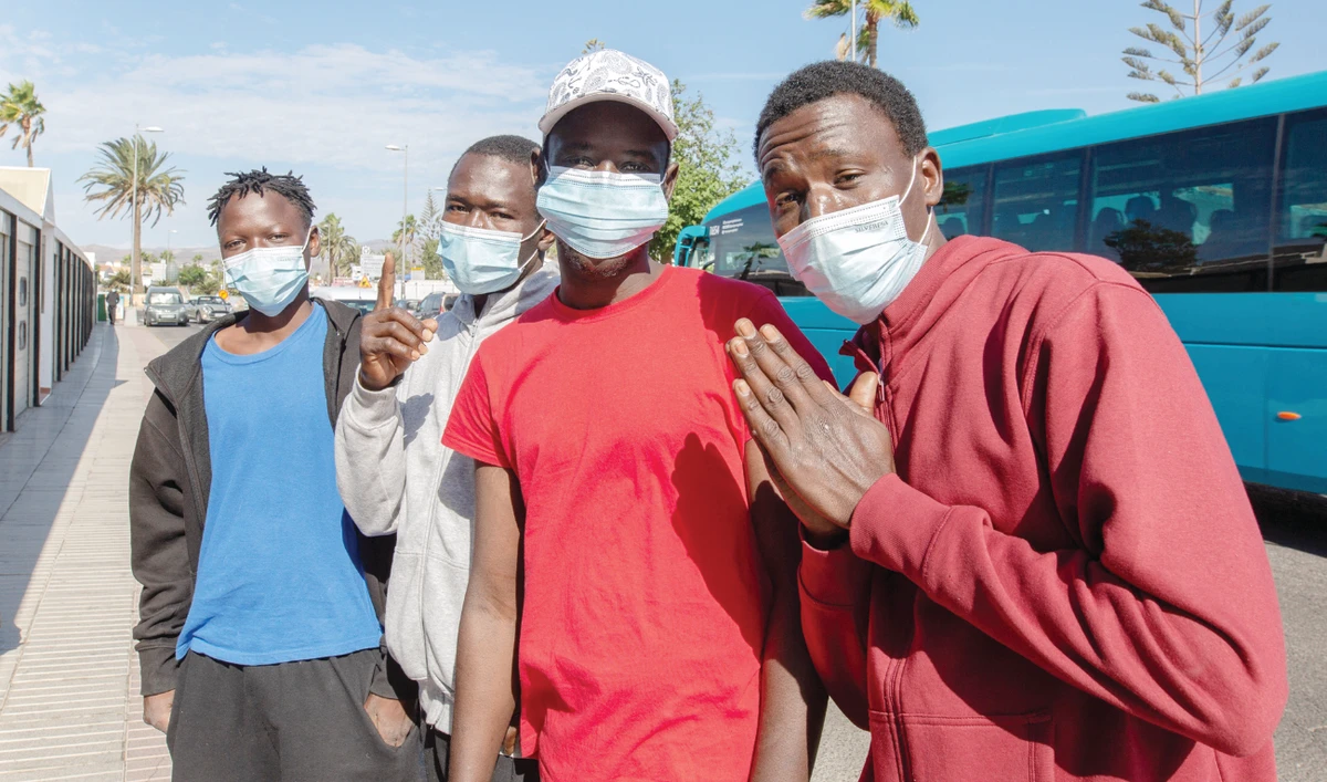 Malian migrants gesture as they wait to be transferred to their accommodation after arriving by boat on the Canary Island of Gran Canaria in 2020. (AFP/File)