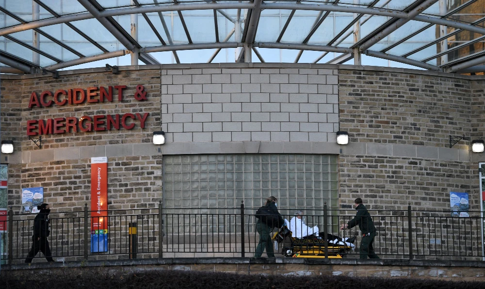 Paramedics push a patient on a trolley outside the Accident and Emergency (A&E) department at Bradford Royal Infirmary hospital in Bradford, northern England on January 5, 2022. (AFP)