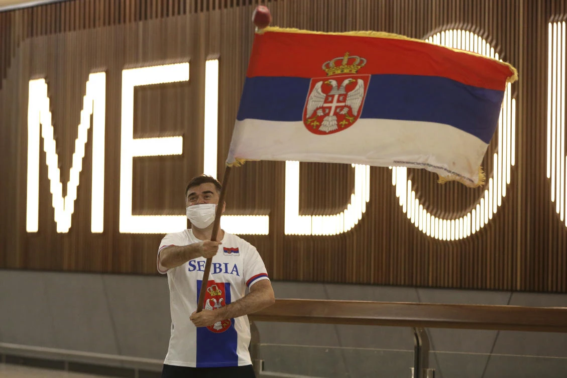 Above, a fan of Novak Djokovic in the arrivals hall at Melbourne Airport ahead of the Australian Open. The Serb’s announcement that he had received a medical exemption to play provoked outrage in Melbourne. (AP)