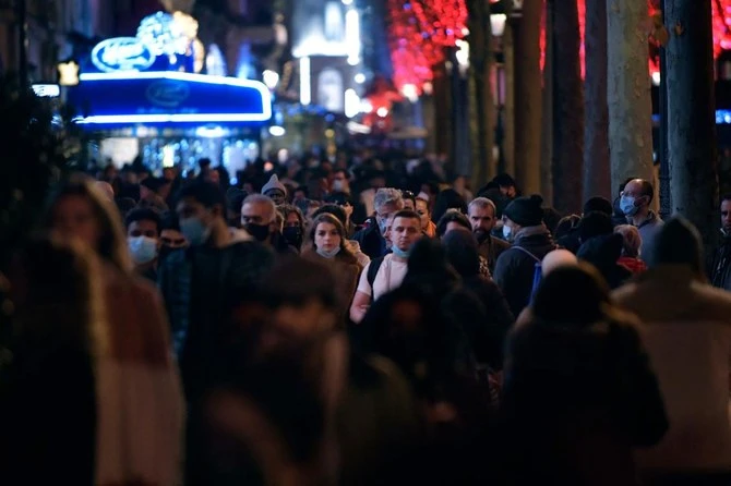 Pedestrian walk on the Champs-Elysees Avenue in Paris, during the New Year Eve after which the face mask became mandatory again in the streets to prevent the spread of Covid-19. (AFP)