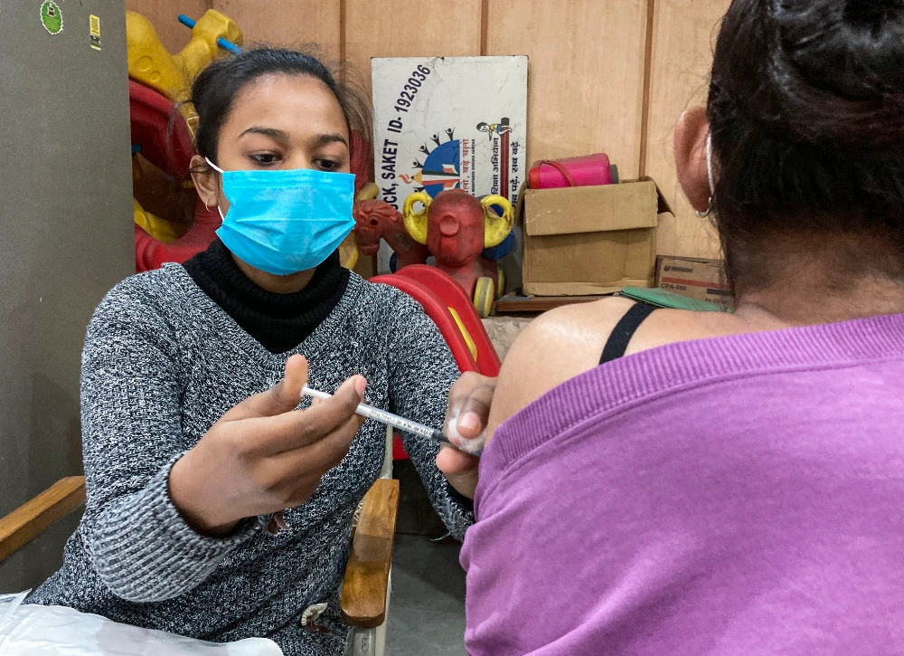 A health worker administers COVID-19 vaccine to a teenager in New Delhi, India, Wednesday, Jan.5, 2022. (AP)
