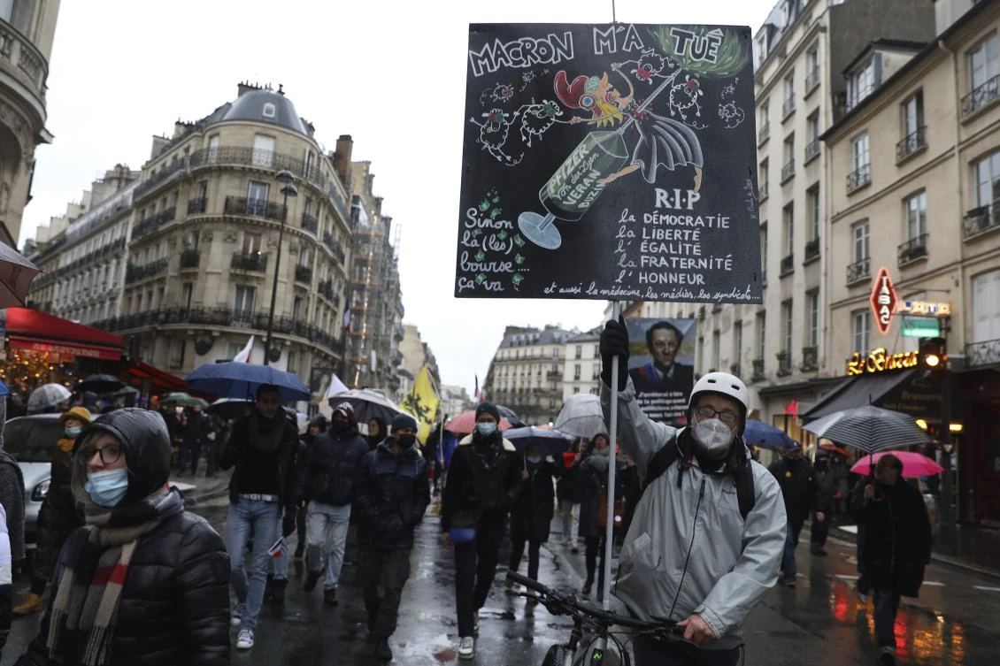 A protester holds a placard that reads “Macron killed me“’ during a rally by demonstrators in opposition to vaccine pass and vaccinations to protect against COVID-19 in Paris on Saturday. (AP)
