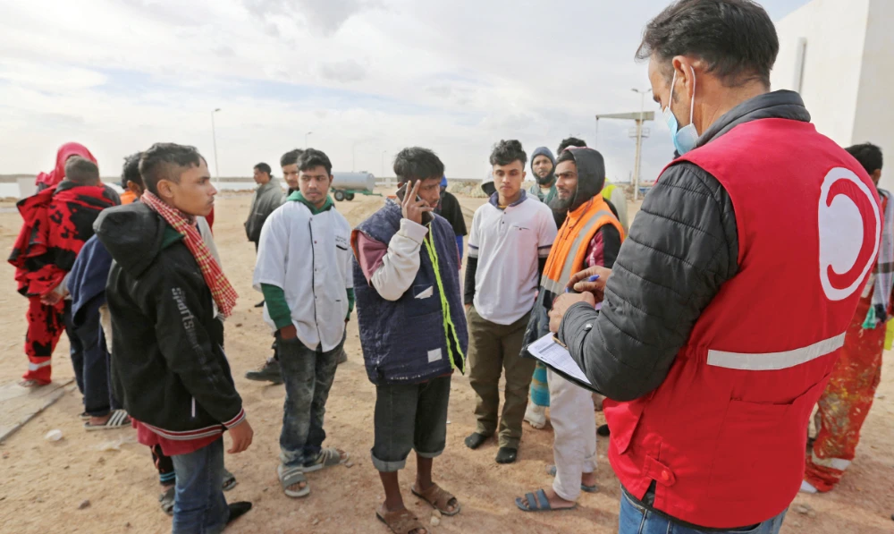 Migrants, rescued by Tunisia’s national guard during an attempted crossing of the Mediterranean by boat, rest on the beach at the port of El-Ketef in southern Tunisia. (File/AFP)