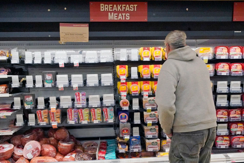 A shopper at a grocery in Pittsburgh looks at the partially empty display of breakfast meats on Tuesday, Jan. 11, 2022. (AP)