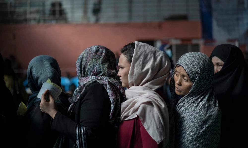 People wait in queues to receive cash at a money distribution organized by the World Food Program (WFP) in Kabul, Afghanistan. (AP/File)
