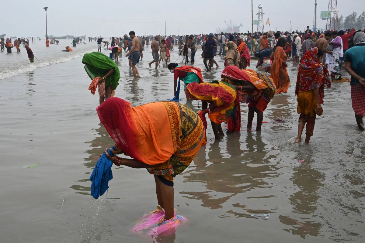 Hindu pilgrims wash their clothes after taking a holy dip at the confluence of Ganges and the Bay of Bengal on Jan.14, 2022. (Dibyangshu Sarkar / AFP)