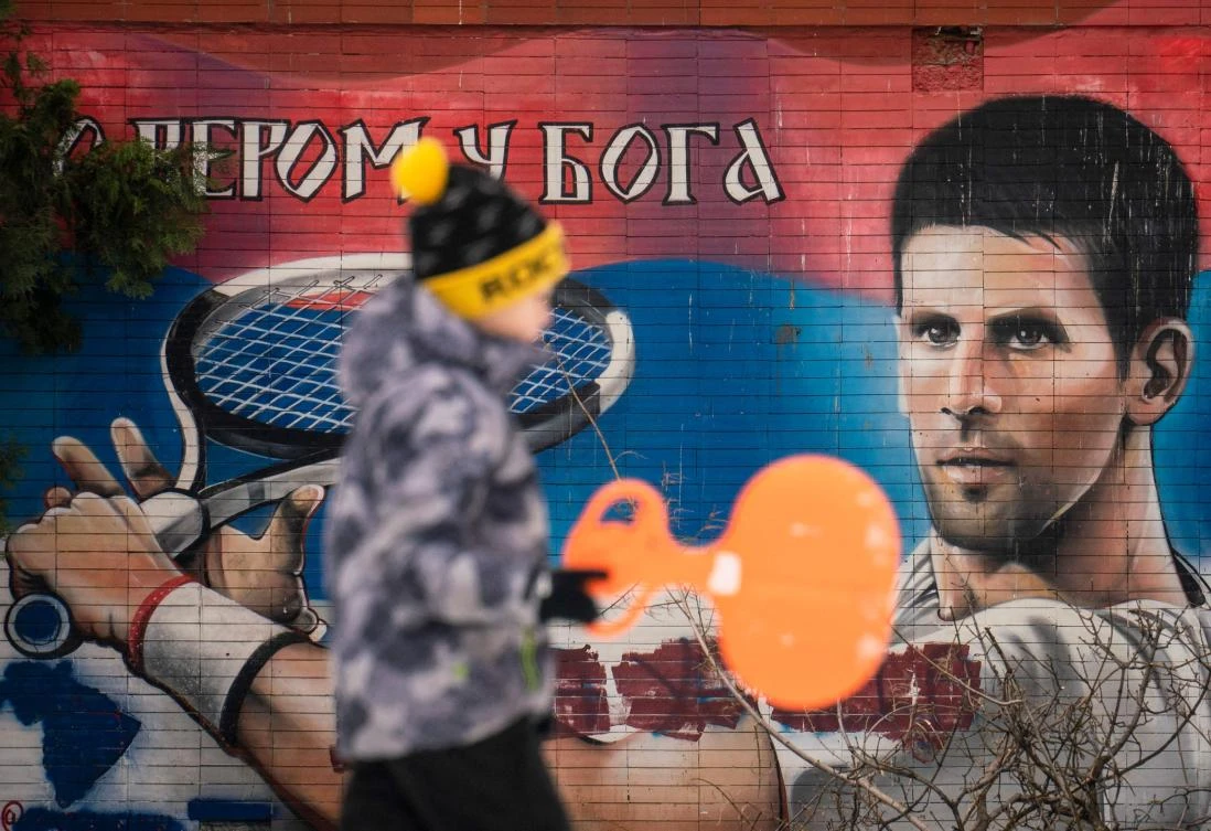 A local resident walks past a mural depicting Serbian tennis player Novak Djokovic in Belgrade on Saturday. (AFP)