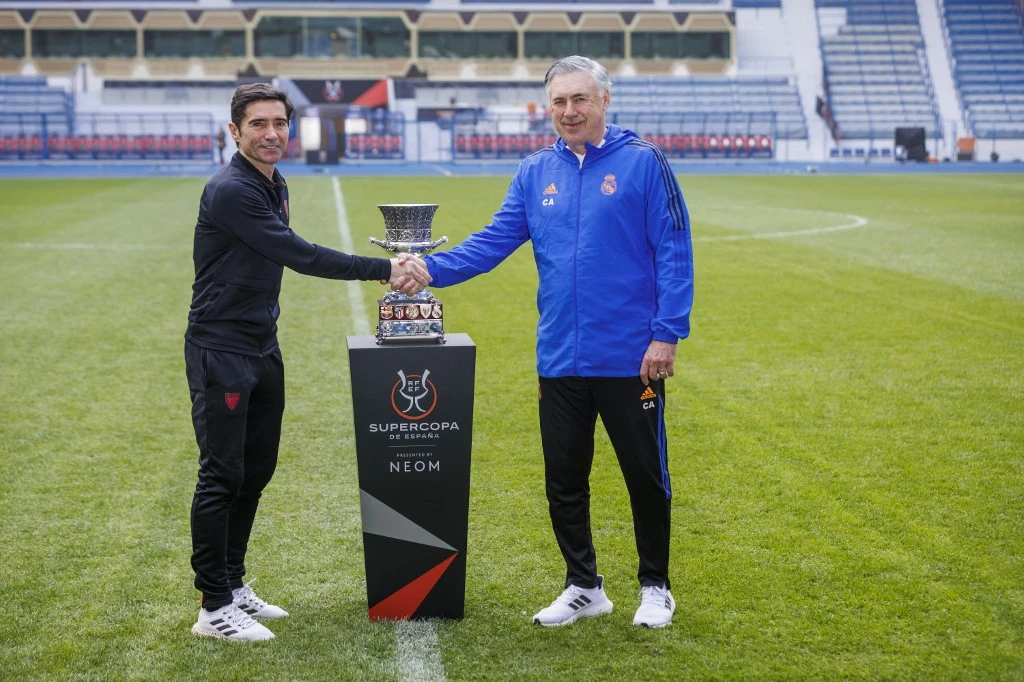 Athletic Bilbao's Spanish coach Marcelino Garcia Toral (L) and Real Madrid's Italian coach Carlo Ancelotti shake hands next to the Spanish Super Cup trophy at the King Fahd stadium in Riyadh. (File/AFP)