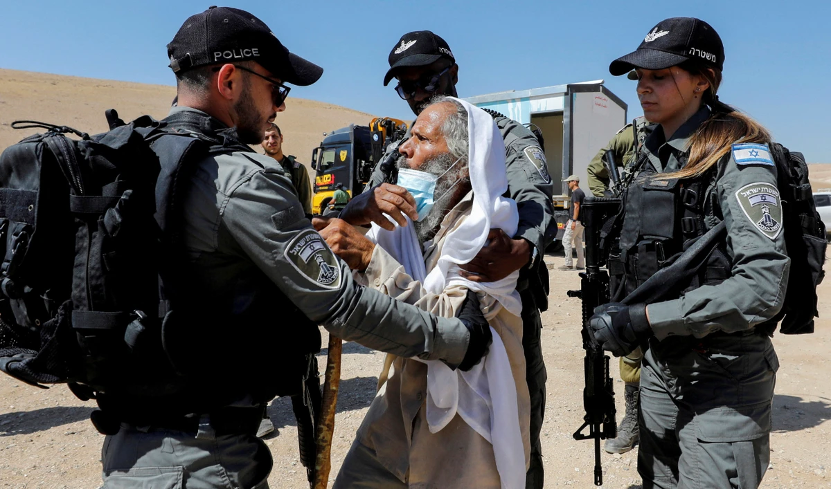 Palestinian Suleiman Al-Hathalin scuffles with Israeli border police members as Israeli forces confiscate a healthcare clinic in Yatta, in the Israeli-occupied West Bank on July 12, 2021. (Reuters)