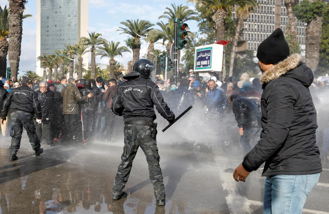 Demonstrators are hit by a water cannon during a protest against Tunisian President Kais Saied’s seizure of governing powers, in Tunis on Friday. (Reuters)