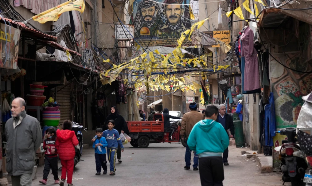 Palestinians walk on a street in the Bourj al-Barajneh Palestinian refugee camp, in Beirut, Lebanon, Tuesday, Jan. 18, 2022. (AP)