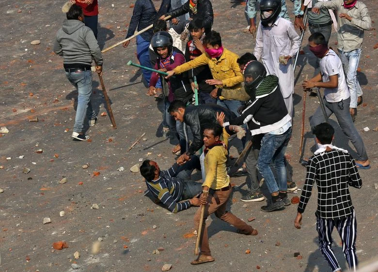 A man is beaten during a clash between people supporting a new citizenship law and those opposing the law in New Delhi, India, February 24, 2020. (REUTERS)