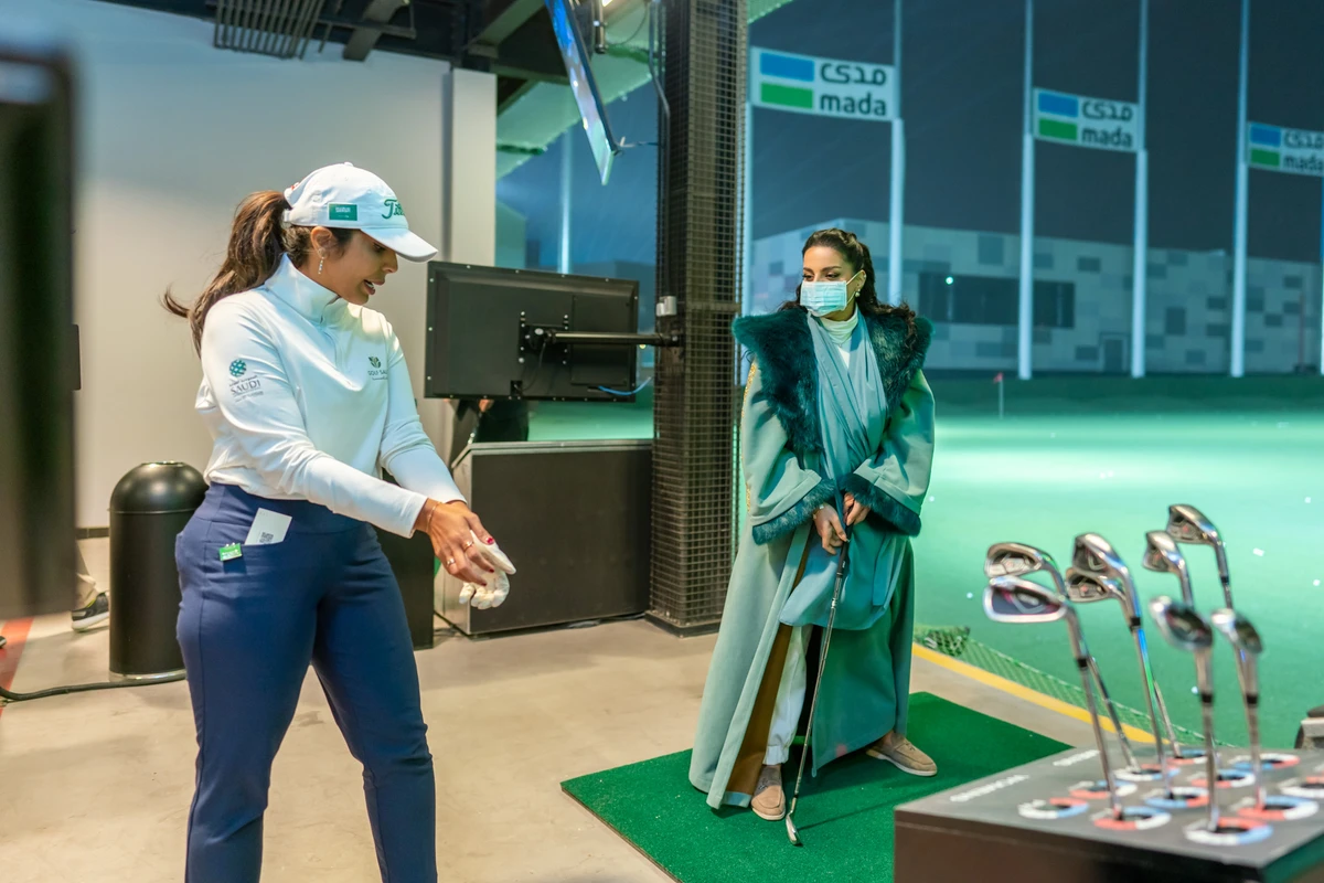Saudi golf coach Reem Alqubaisi gives a newcomer tips on the game during the event at Riyadh City Boulevard. (Golf Saudi)
