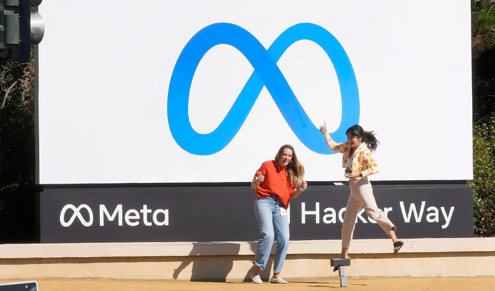 Facebook employees take a photo with the company's new name and logo outside its headquarters in Menlo Park, Calif., Oct. 28, 2021. (AP)