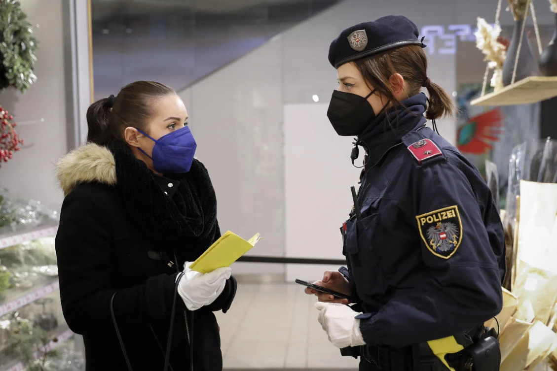 A police officer checks the vaccination status of a visitor during a patrol in a shopping mall in Vienna, Austria, Wednesday, Jan. 12, 2022. (AP)