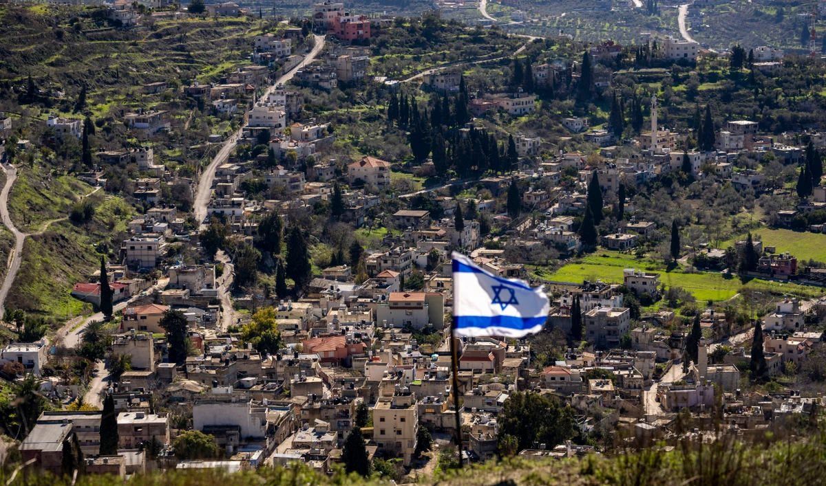The Palestinian village of Burqa is seen as an Israeli flag is placed in the Jewish West Bank outpost of Homesh, Monday, Jan. 17, 2022. (AP)