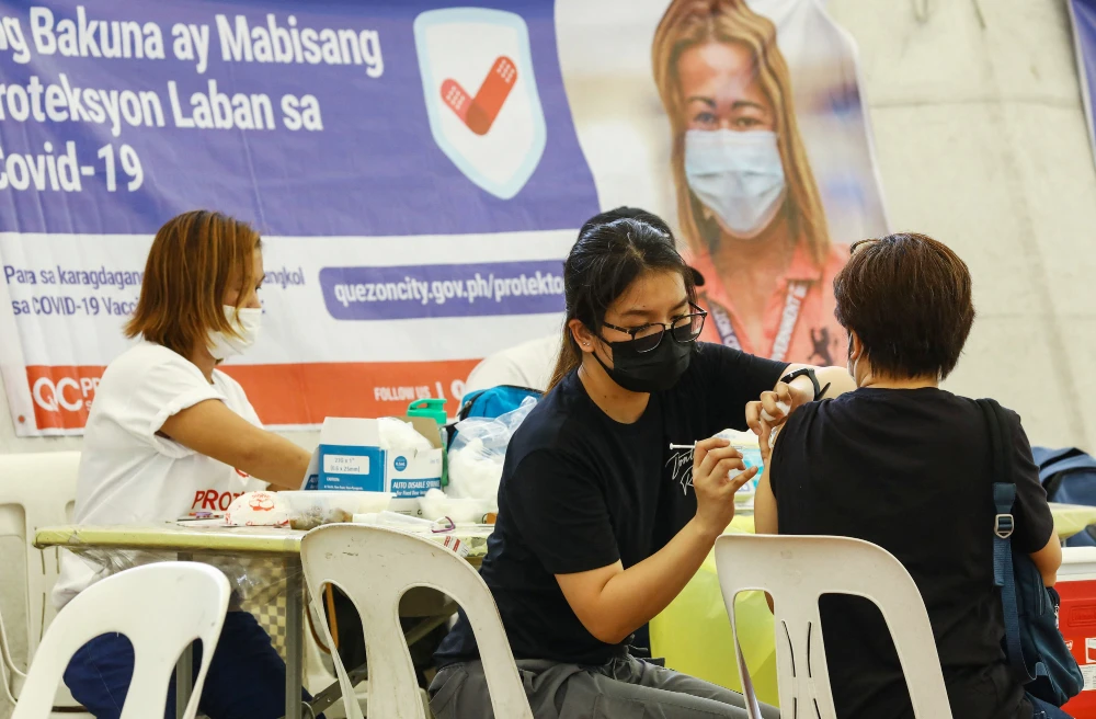 A resident receives a BioNtech Pfizer Covid-19 jab as a booster, at a vaccination center in Quezon city on January 27, 2022, amidst rising covid-19 infections in the capital driven by Omicron variant. (AFP)