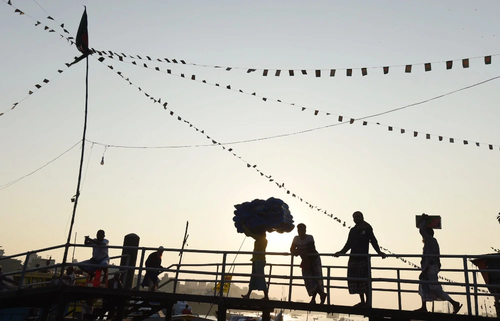 Labourers carry goods to load on a boat in Buriganga river in Dhaka. (AFP file photo)